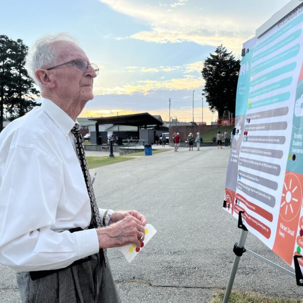 elderly man looking at poster board
