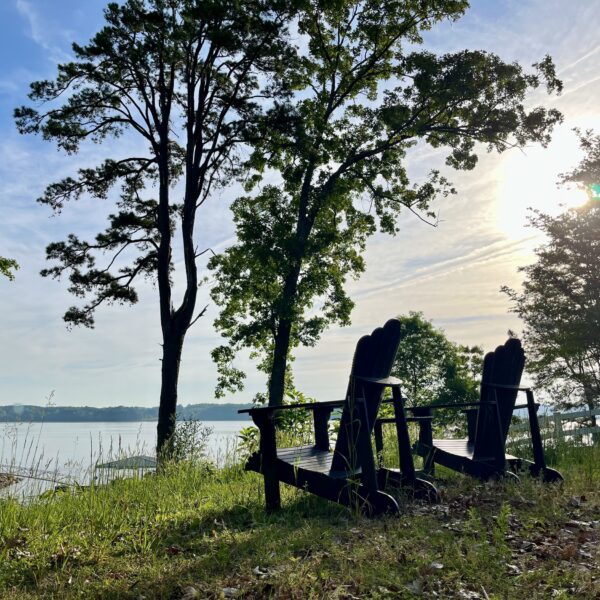 two adirondack chairs next to lake