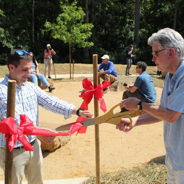 two men cutting a ribbon at the monacan indian nation tribute park