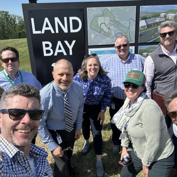 team members standing outside by a land bay sign
